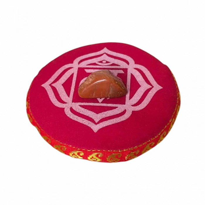 Kit chakra complet avec bougie blanche, coussin rouge, pierre semi-précieuse et bougeoir racine sur fond rouge vibrant.