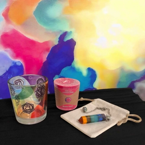 Kit Basic Vibes, bien-être coloré avec bougeoir chakras, bougie Terre Mère, pendule et pochette, posé sur fond lumineux. Kit rituel énergétique chakra, affirmations et rituel mantra du matin.