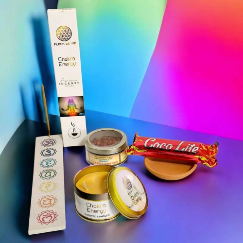 Kit Chakra Energy avec bougie parfumée, encens, résine, charbon de coco et accessoires, sur fond arc-en-ciel vibrant. Kit rituel énergétique chakra, affirmations et rituel mantra du matin.