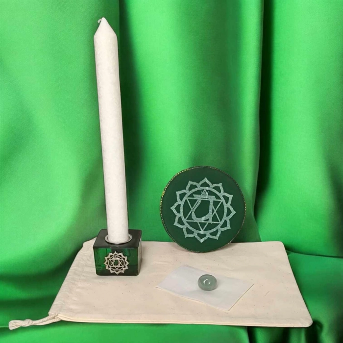 Kit rituel énergétique chakra complet avec bougie blanche, coussin rouge, pierre semi-précieuse et bougeoir racine sur fond rouge vibrant.