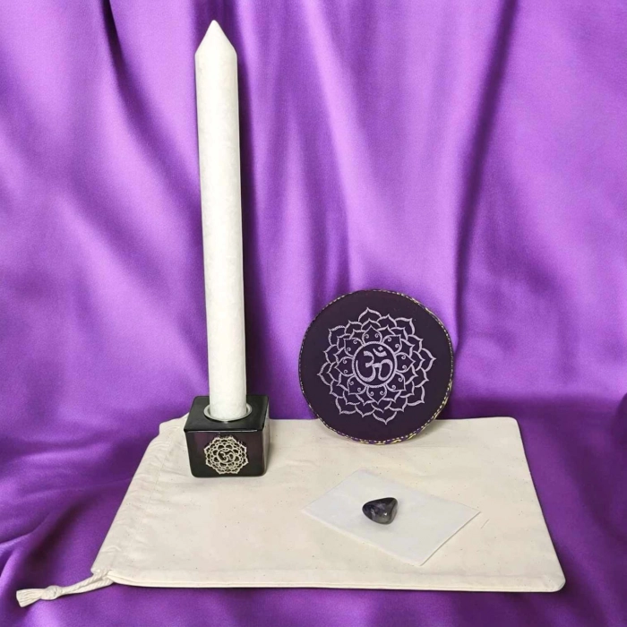 Kit rituel énergétique chakra complet avec bougie blanche, coussin rouge, pierre semi-précieuse et bougeoir racine sur fond rouge vibrant.