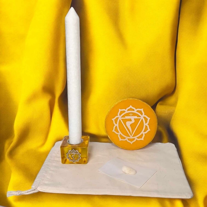 Kit rituel énergétique chakra complet avec bougie blanche, coussin rouge, pierre semi-précieuse et bougeoir racine sur fond rouge vibrant.
